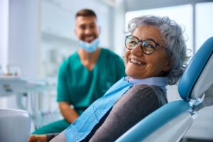 A dental hygienist reviews X-rays with a middle-aged patient during a routine checkup in a well-lit clinic.